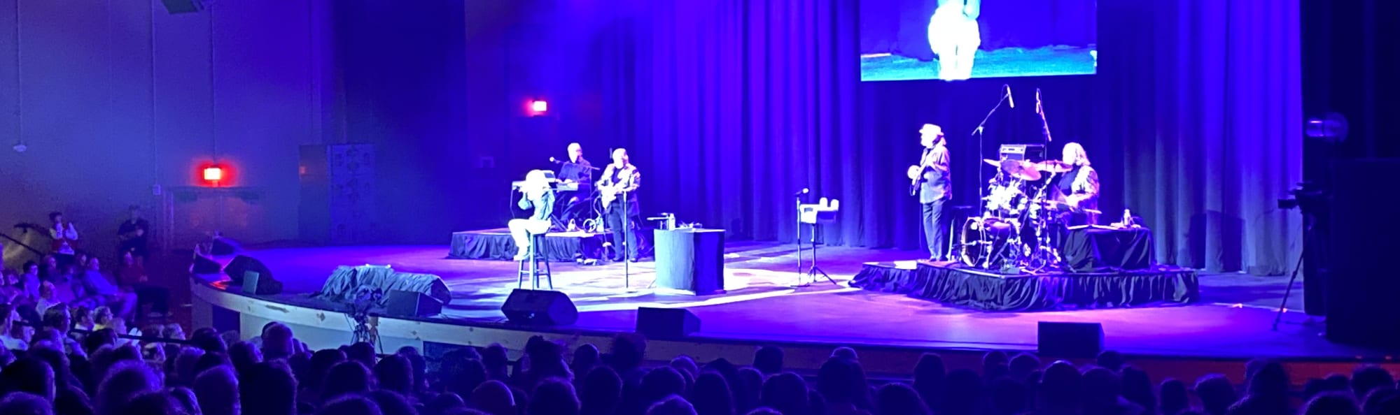 signer on stage in chair washed out by the lights Inland Empire